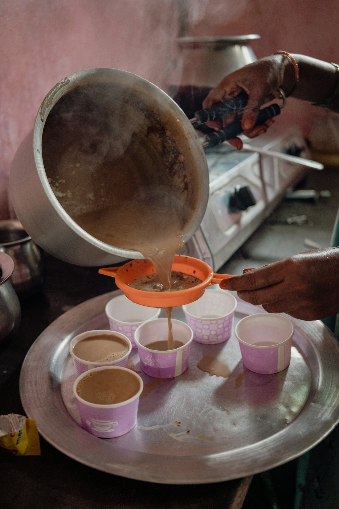A person pouring a cup of coffee on top of a plate