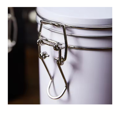 Close-up of a metal clasp on a white container with a blurred background